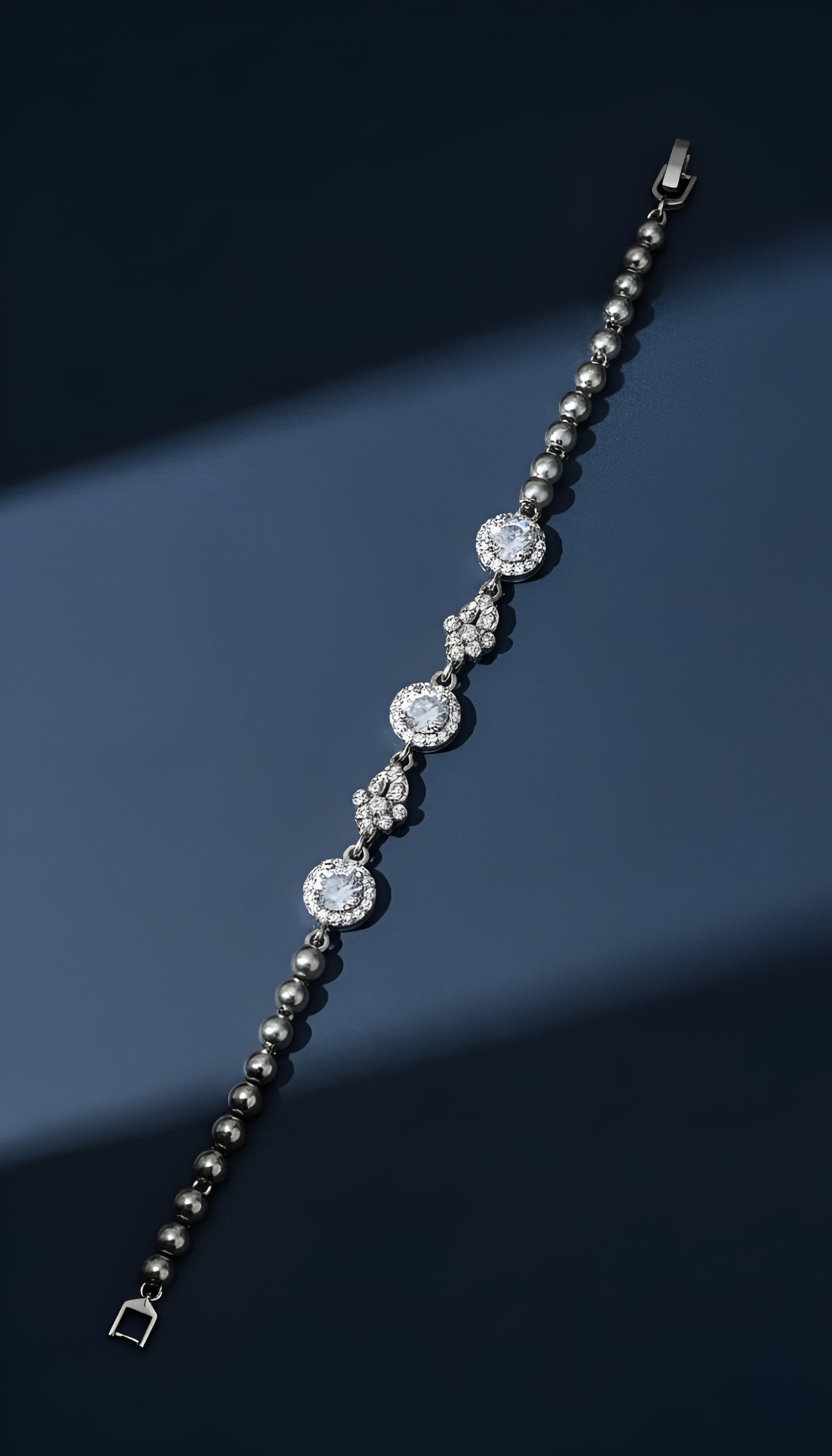 Silver bracelet with diamond-like beads on a dark blue background