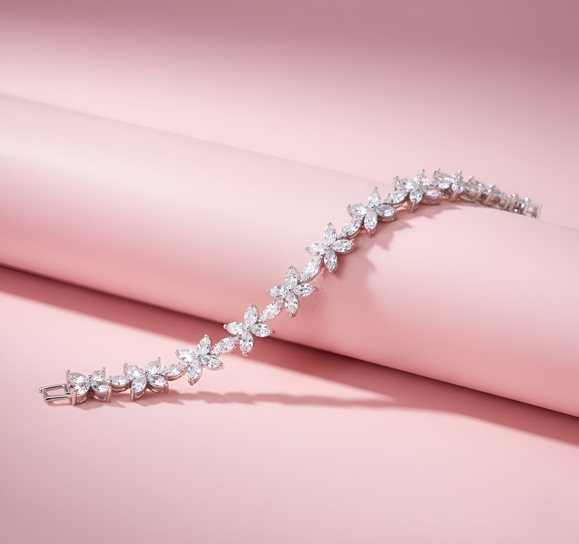 Silver bracelet with floral design on a pink fabric background